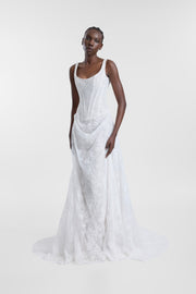 A model wearing an ivory lace wedding gown with a scoop neckline, corseted bodice and draped A-line skirt, photographed against a seamless light grey studio background.