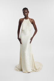 Model wearing the Mylo ivory sequin wedding gown with a halter neckline, open back, body-skimming silhouette and soft train.